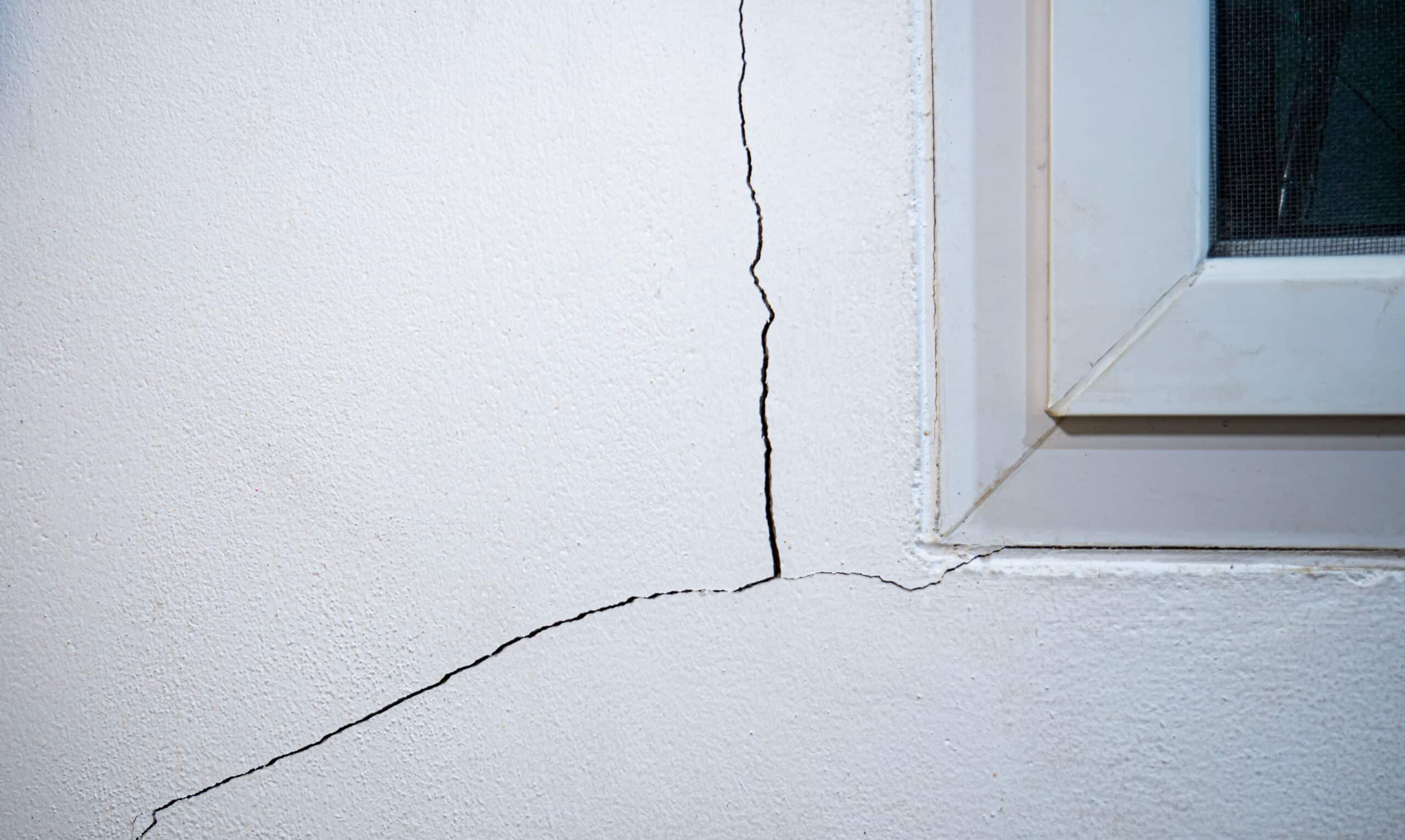 Cracks on the wall. The crack in the cement wall at the window s