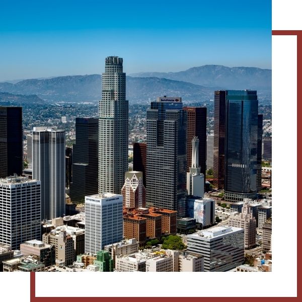 Cities We Serve Skyline of modern skyscrapers with mountains in the distance