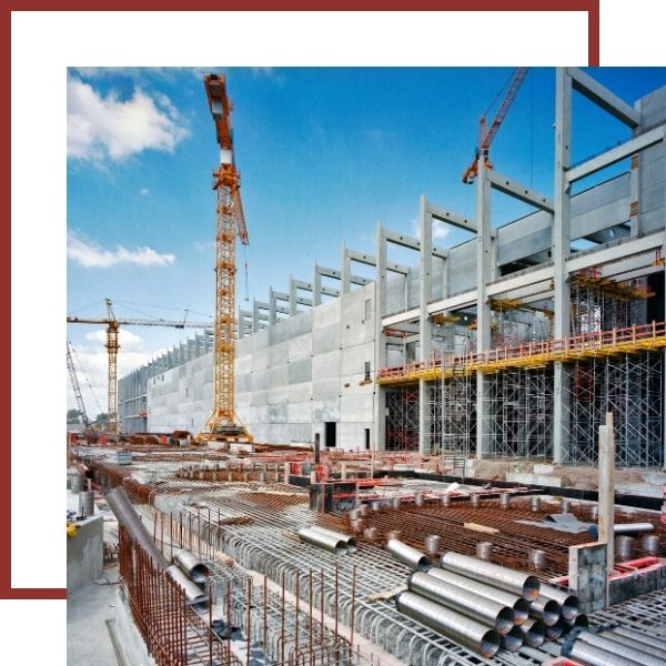 Commercial Construction Services Construction site with cranes, scaffolding, and unfinished building