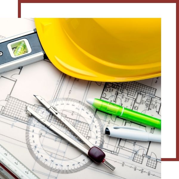 General Contracting and Custom Projects Yellow hard hat and drafting tools on architectural blueprint