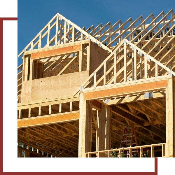 Residential Construction Services Wooden house frame under construction with blue sky background